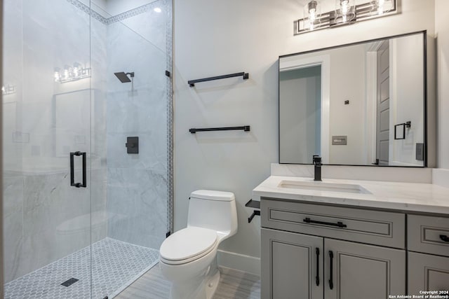 bathroom with vanity, toilet, and a shower with door