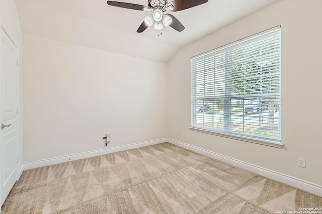 carpeted empty room with ceiling fan and vaulted ceiling