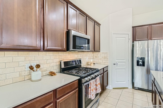 kitchen featuring decorative backsplash, light tile patterned flooring, and appliances with stainless steel finishes