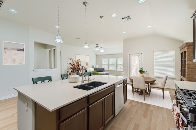 kitchen with ceiling fan, sink, stainless steel appliances, light hardwood / wood-style floors, and a kitchen island with sink