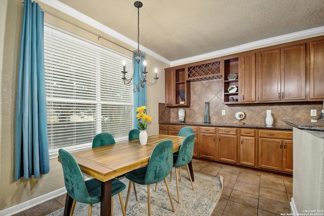 dining area with a textured ceiling, an inviting chandelier, crown molding, and light tile patterned flooring