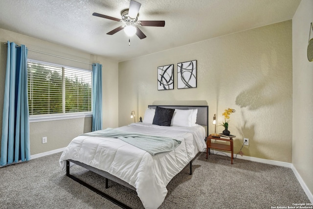 carpeted bedroom featuring ceiling fan and a textured ceiling