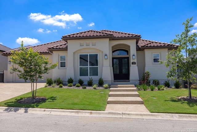 mediterranean / spanish home featuring french doors and a front lawn