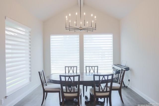 dining room with a chandelier, hardwood / wood-style floors, a wealth of natural light, and lofted ceiling