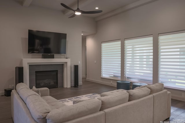 living room featuring beam ceiling, a tile fireplace, ceiling fan, and a healthy amount of sunlight