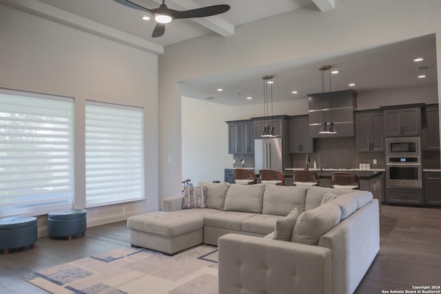 living room with beam ceiling, ceiling fan, and light hardwood / wood-style flooring