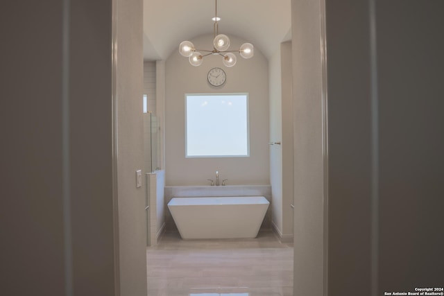 bathroom featuring a bathtub, hardwood / wood-style floors, and a notable chandelier