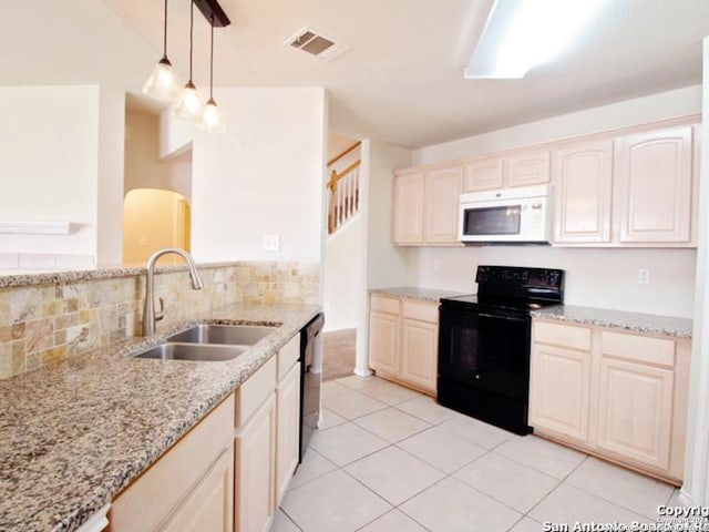 kitchen with pendant lighting, black appliances, sink, light stone countertops, and light tile patterned floors