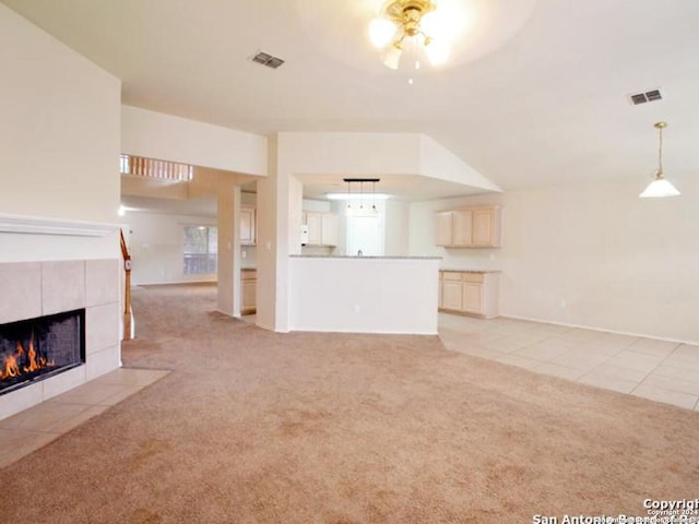 unfurnished living room with ceiling fan, light tile patterned floors, and a fireplace