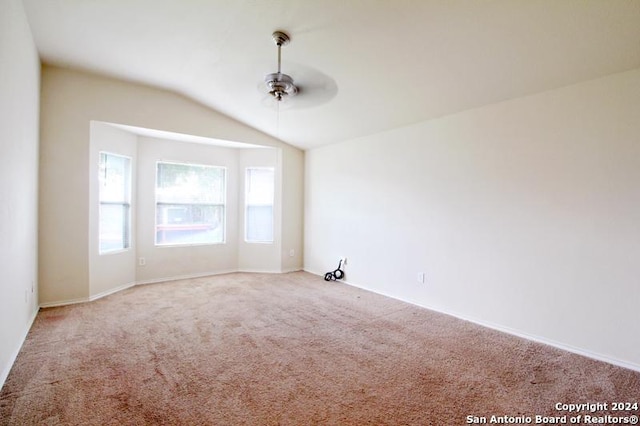 empty room with ceiling fan, light colored carpet, and lofted ceiling