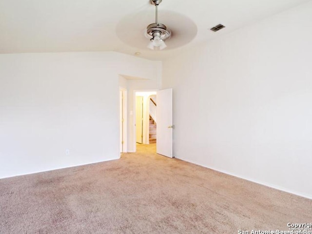 empty room with ceiling fan, light carpet, and vaulted ceiling