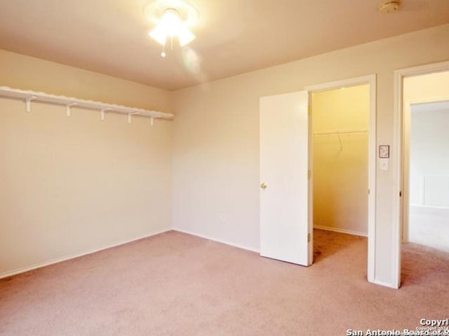 unfurnished bedroom with carpet, a spacious closet, and a closet