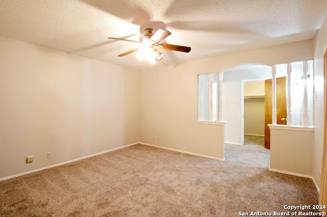 carpeted empty room featuring ceiling fan and a textured ceiling