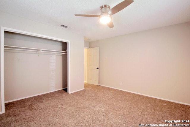 unfurnished bedroom featuring ceiling fan, a closet, and light colored carpet