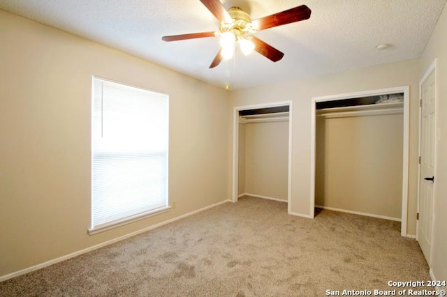 unfurnished bedroom featuring a textured ceiling, ceiling fan, and light carpet