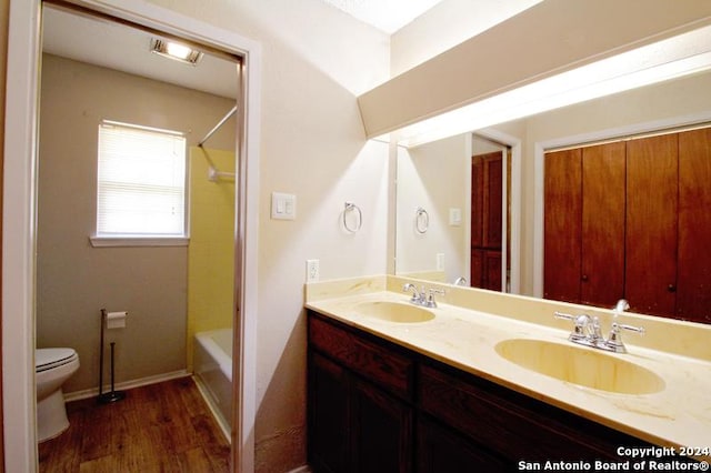 full bathroom featuring hardwood / wood-style floors, vanity,  shower combination, and toilet