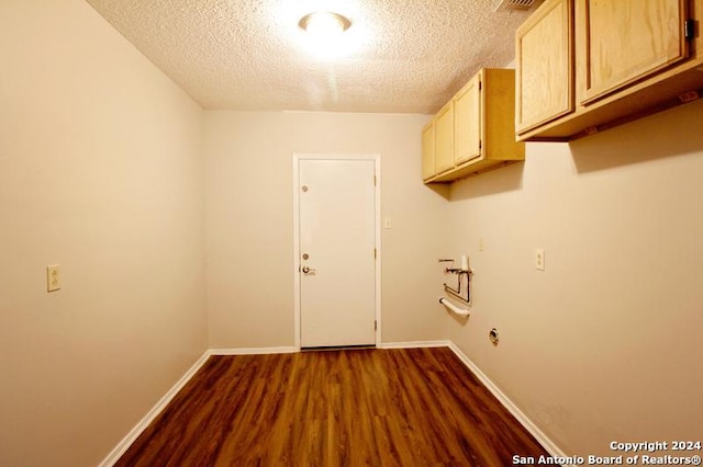 clothes washing area with dark hardwood / wood-style floors, cabinets, a textured ceiling, and hookup for a washing machine