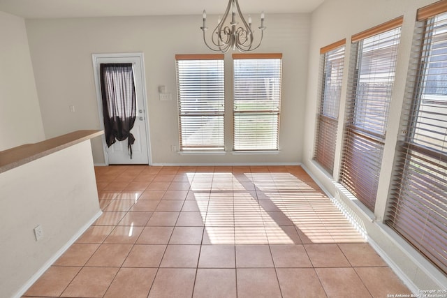 unfurnished dining area featuring light tile patterned floors and a chandelier