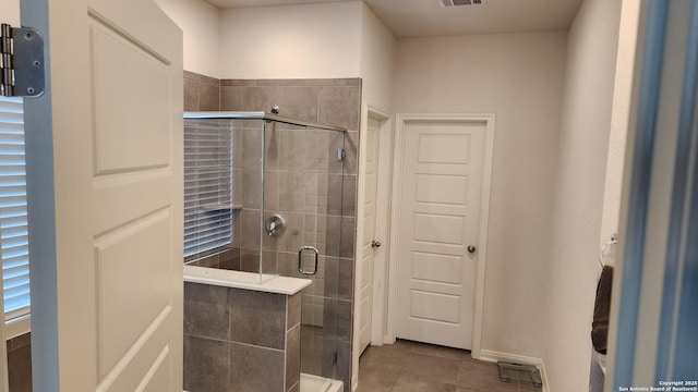 bathroom featuring tile patterned flooring and a shower with door