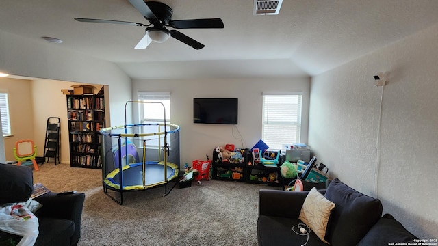 playroom featuring ceiling fan, a healthy amount of sunlight, carpet floors, and vaulted ceiling