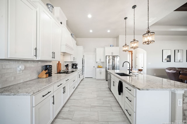 kitchen with decorative light fixtures, white cabinetry, and a large island