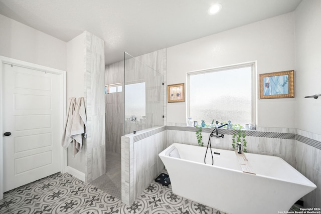 bathroom with tile patterned floors, sink, and plus walk in shower