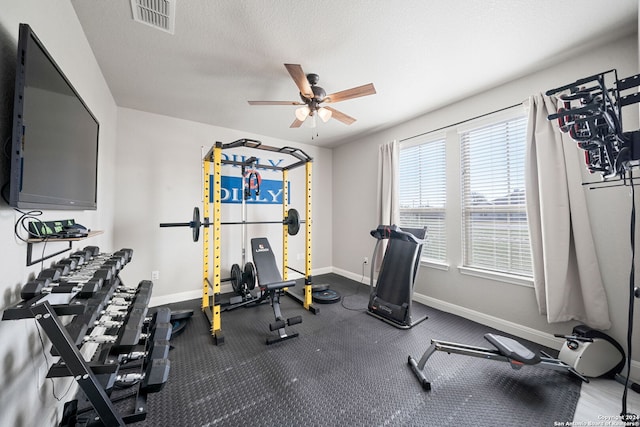 workout room with ceiling fan and a textured ceiling