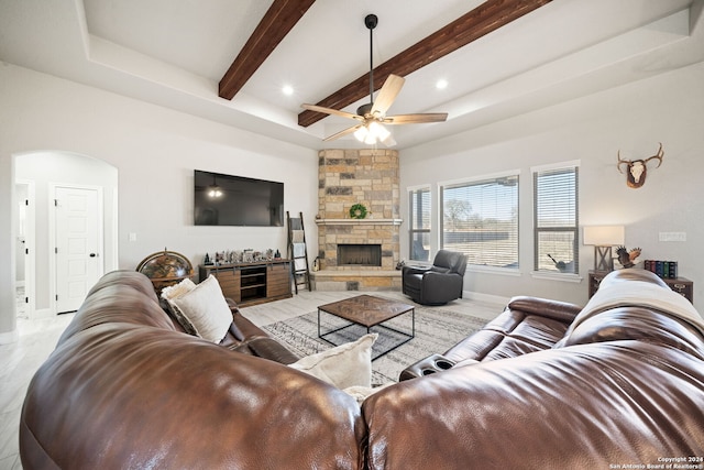 living room featuring beamed ceiling, ceiling fan, and a fireplace