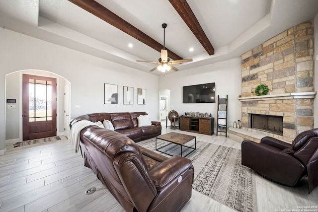 living room with ceiling fan and a stone fireplace