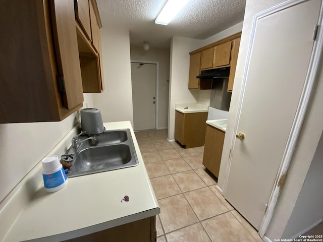 kitchen featuring light tile patterned floors, a textured ceiling, and sink