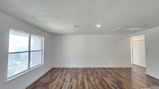 unfurnished room with dark hardwood / wood-style floors and a textured ceiling