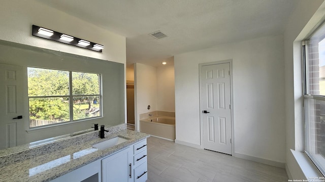 bathroom with vanity and a tub