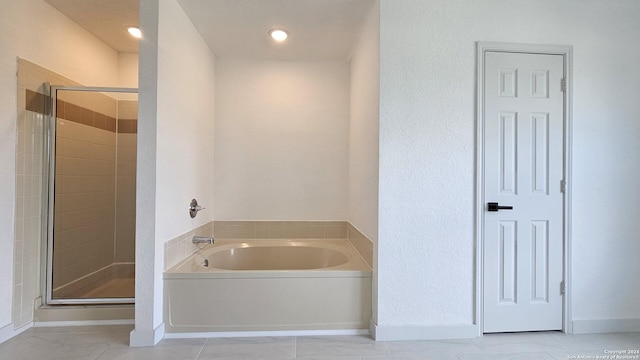 bathroom featuring tile patterned flooring and shower with separate bathtub