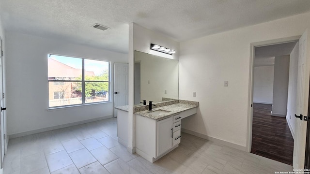 bathroom with vanity and a textured ceiling