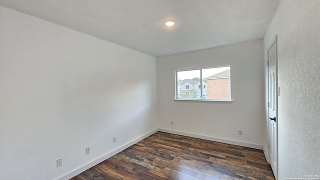 unfurnished room with dark hardwood / wood-style flooring