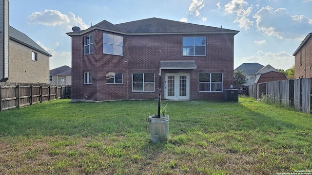 back of house featuring a lawn and french doors