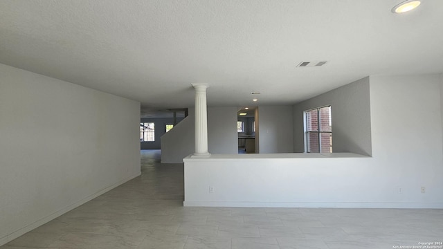 unfurnished room featuring decorative columns