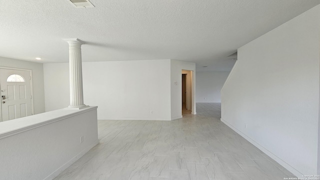 unfurnished room featuring decorative columns