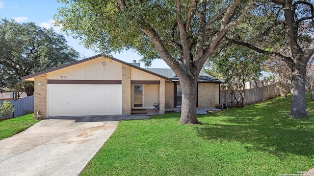 view of front of house featuring an attached garage, brick siding, fence, and a front lawn