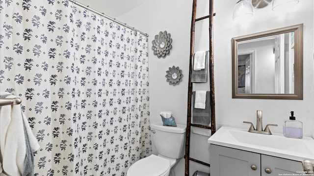 bathroom featuring curtained shower, vanity, and toilet