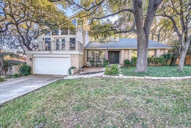 view of front of property with a garage, a balcony, and a front lawn