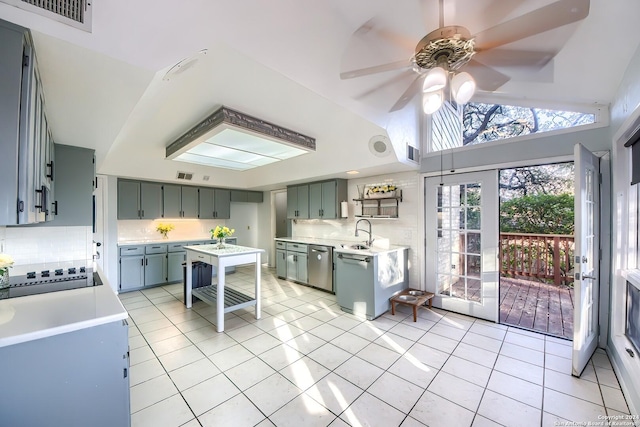 kitchen with ceiling fan, dishwasher, sink, tasteful backsplash, and vaulted ceiling