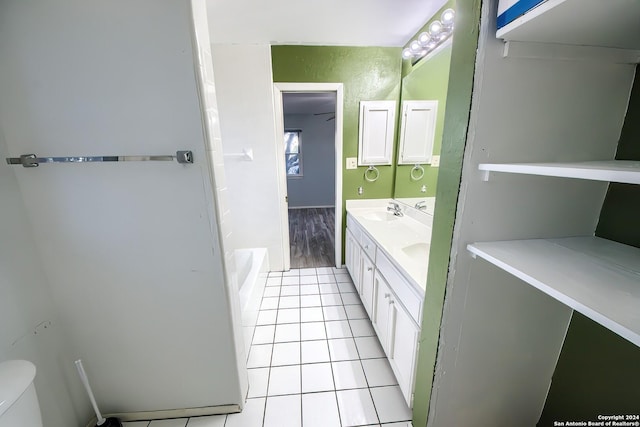 bathroom featuring tile patterned floors, vanity, toilet, and a bathtub