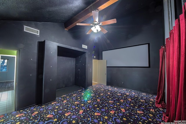 home theater room featuring lofted ceiling with beams, ceiling fan, and carpet floors