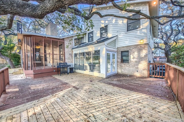 rear view of house with a sunroom and a deck