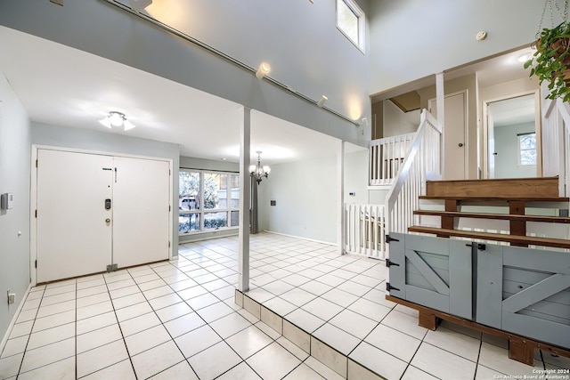 tiled foyer entrance featuring a towering ceiling and an inviting chandelier