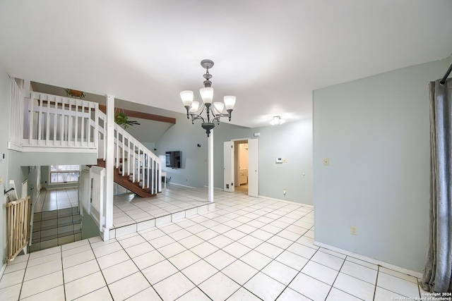 interior space with ceiling fan with notable chandelier, light tile patterned floors, and vaulted ceiling