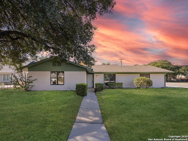 ranch-style home featuring a lawn