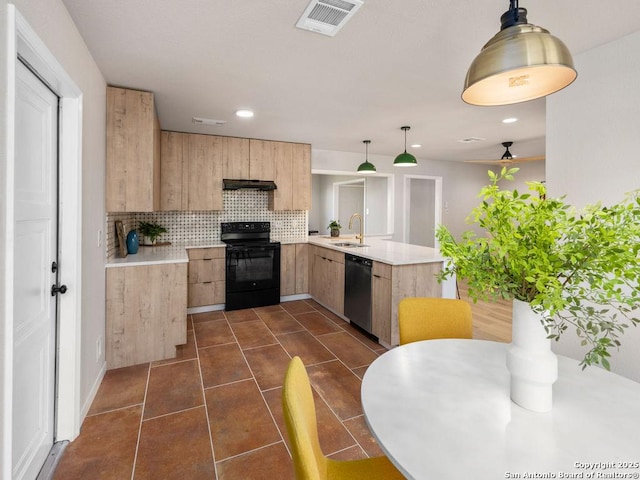 kitchen featuring kitchen peninsula, decorative backsplash, sink, black appliances, and pendant lighting