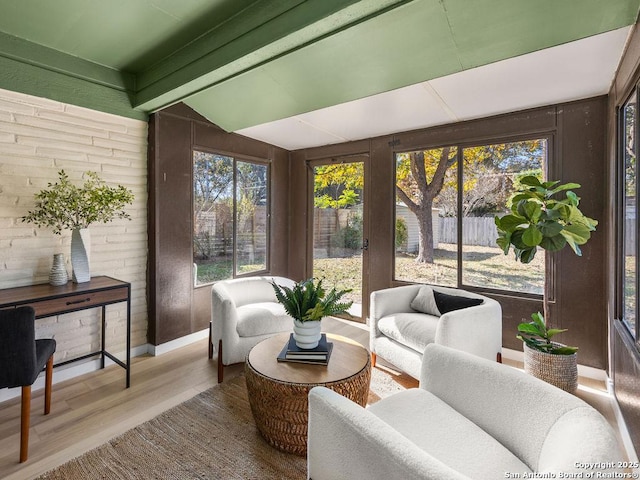 sunroom / solarium featuring plenty of natural light and lofted ceiling with beams